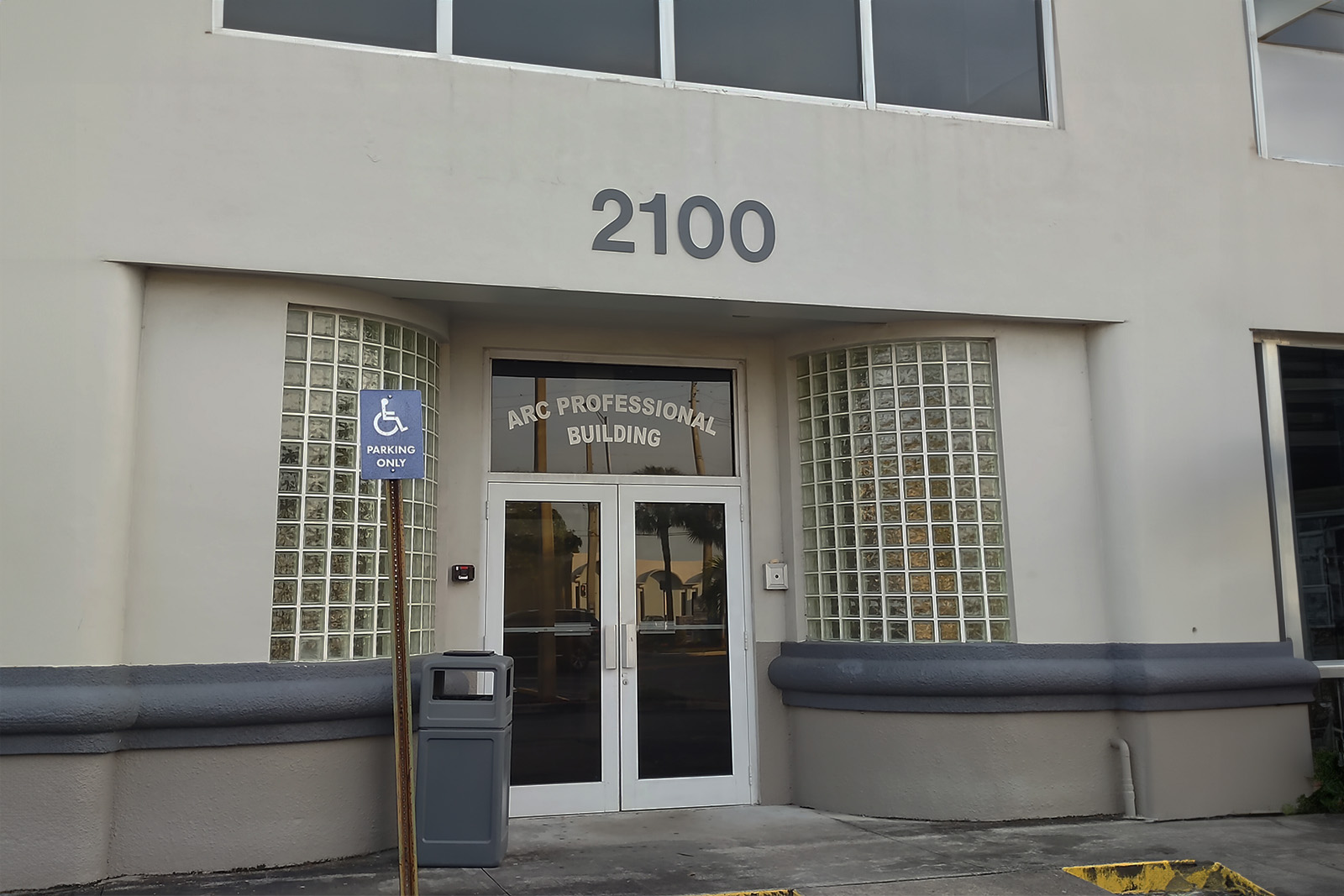 The image shows a building entrance with a sign above the door reading '210 PROFESSIONALS' and a number '210' below it, indicating the address of the establishment.